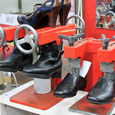 shoe machine stretching out a leather shoe and pair of heels